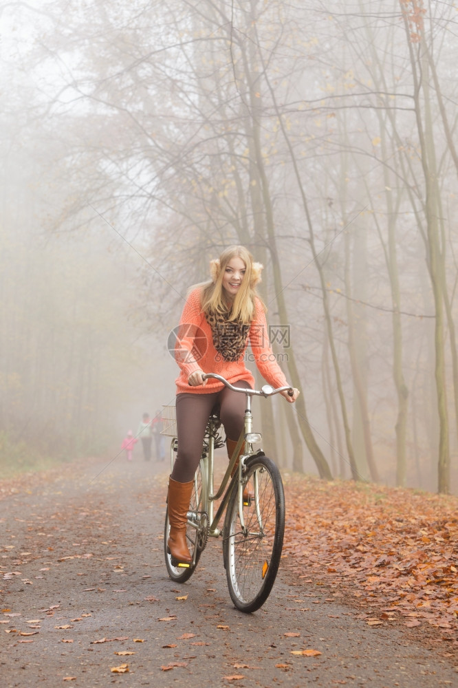 快乐的女孩在森林公园骑着自行车图片