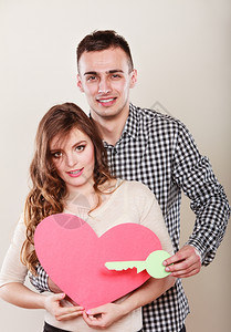 带着纸键的年轻夫妇拿着纸键打开心的爱符号夫妻图片