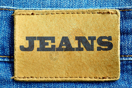 黄色绸带标签蓝色牛仔裤和皮革标签背景