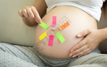孕妇选择多彩备忘录贴纸的概念镜头图片