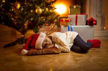 可爱的女孩在圣诞树下睡着等待圣诞老人图片