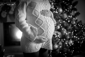 孕妇在圣诞树上拥抱肚子的照片图片