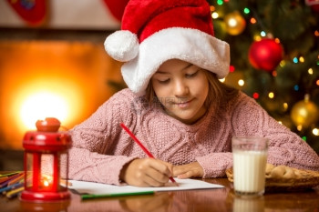 可爱女孩在客厅写信给圣诞老人的肖像图片
