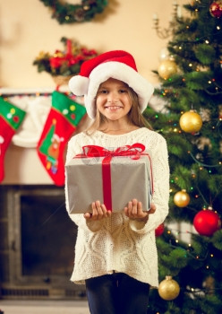 装着圣诞礼物盒的塔帽快乐女孩的画像图片