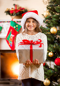 带着大圣诞礼物盒的快乐小女孩肖像图片