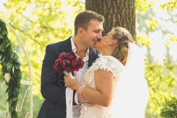 结婚典礼上在花园接吻的幸福新娘和郎的画像图片
