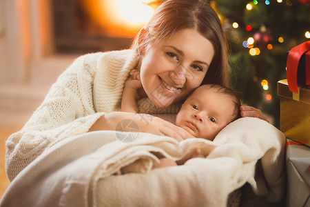 圣诞摆台穿着毛毯的婴儿母亲和男孩在圣诞节房间里摆着背景