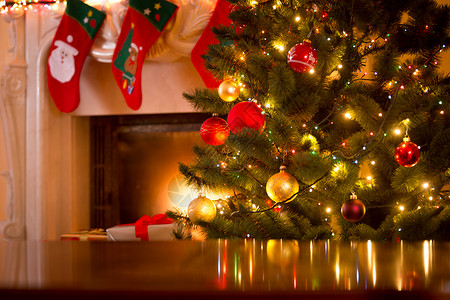 与装饰圣诞树和壁炉相比的木桌圣诞节假日背景图片
