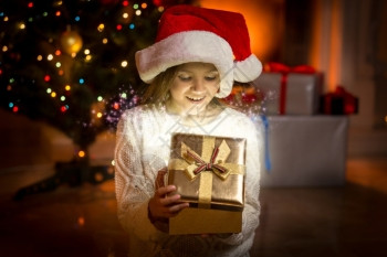 小女孩的肖像装着闪发光的金礼物盒图片