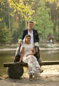 坐在河岸长椅上的英俊新郎拥抱娘的照片图片