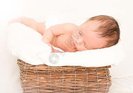睡在被毯子覆盖的旧篮里可爱新生婴儿男孩图片