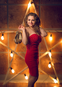 穿着红裙子的微笑女人脱鞋与大亮星对决的画像图片