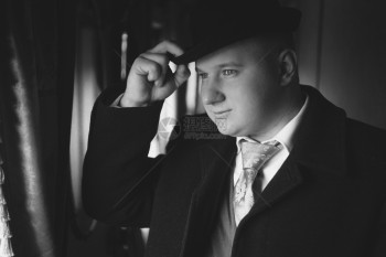 穿着保龄球帽的男子黑白近身肖像望着火车窗外图片