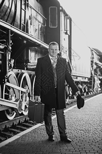 穿着西装等待火车的英俊男子黑白旧照图片