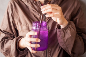 女手持冰饮用紫玻璃配有旧过滤器股票照片图片