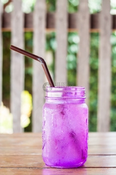 在咖啡店的紫玻璃里喝彩酒股票照片图片