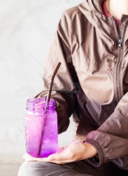 女手持冰饮用紫玻璃配有旧过滤器股票照片图片