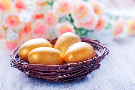 以粉色鲜花为背景的金色鸡蛋图片