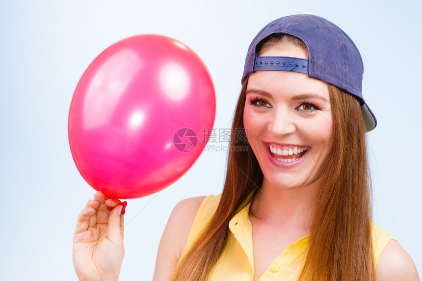 带着红气球快乐的少女带着红色粉气球笑的少女穿着时装的年轻迷人女穿着蓝色背景的时装图片