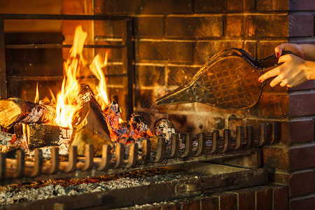 波纹管紧的手壁炉用铃头起火紧的手放在壁炉上用铃头起火暖和放松的人家里冬天背景