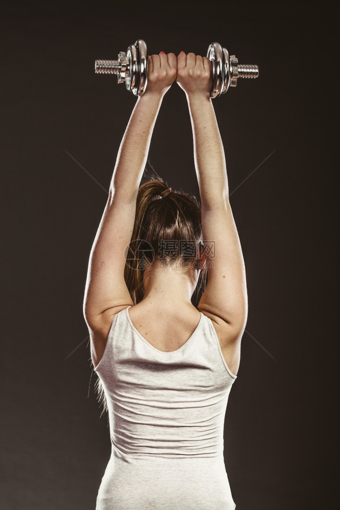 强健的女子举起哑铃重量健美壮的女子举起哑铃重量图片