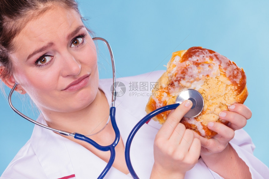 恶心的饮食营养学家检查用听诊器甜面包图片