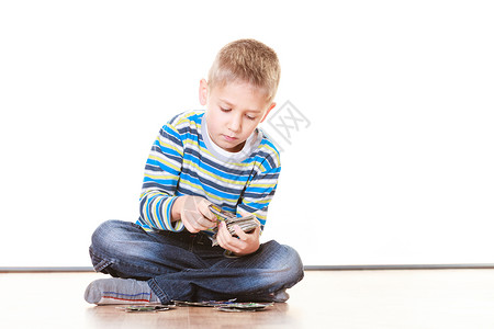 小男孩坐在地板上玩收集卡片图片