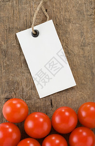 木材背景纹理上的价格标签和番茄蔬菜图片