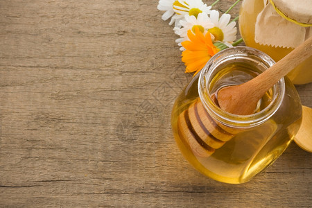 蜂蜜罐子和木本的鲜花图片