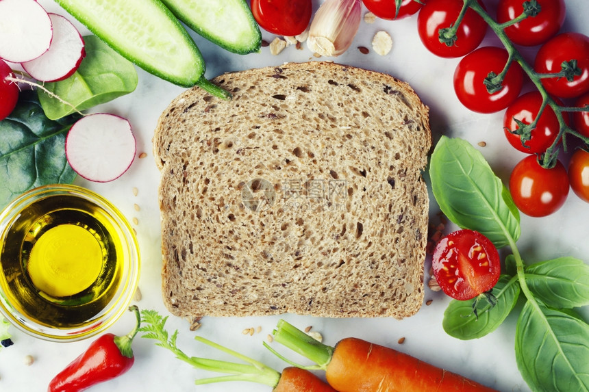整片小麦面包和健康有机蔬菜用于制作三明治健康饮食或烹饪概念图片