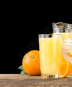 以黑色背景隔离的橙汁和水果图片