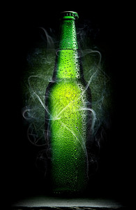 黑色背景的绿啤酒瓶图片