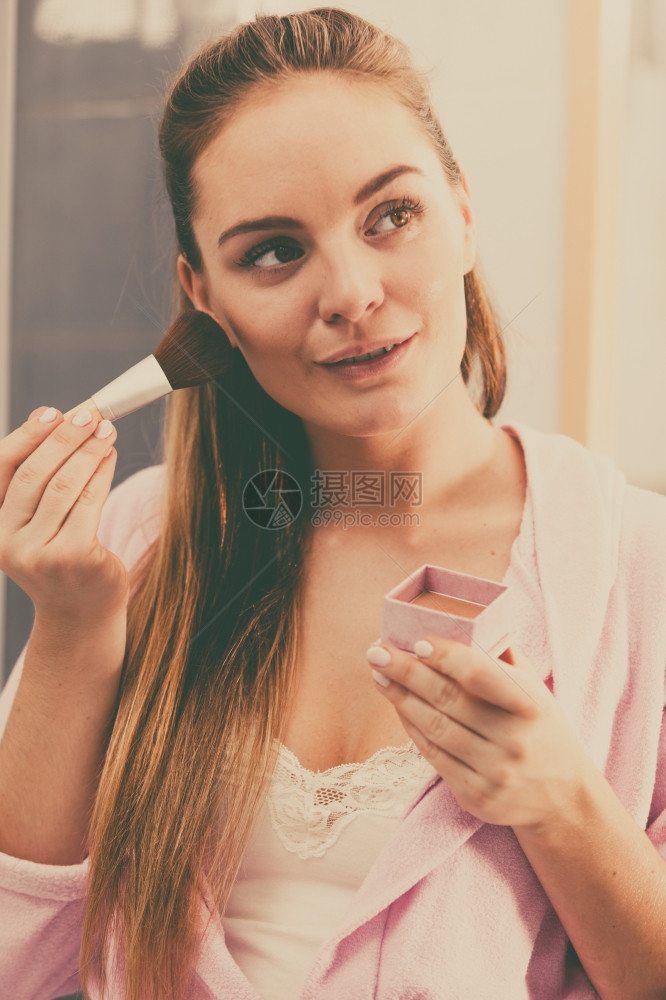 妇女用刷子粉皮肤妇女脸部绘画孩在洗手间里用刷子粉皮肤化妆品和美容程序妇女用刷子粉她的皮肤女孩用抹液粉或青铜在浴室里用刷子粉她的皮图片