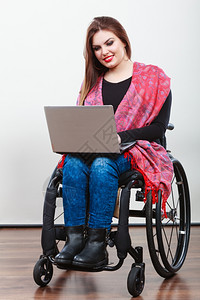 残疾女在网上冲浪青年女在轮椅上使用笔记本电脑互联网技术教育残疾概念图片