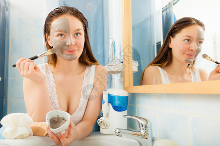 年轻女在洗手间用面部泥粘土罩在脸部露图片