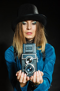 古老的有魅力年轻女孩拿着老旧的相机斯特汉普克摄影师拍照图片