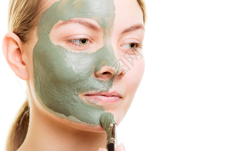 皮肤护理女在面部被孤立时用刷泥蒙面女孩照顾干衣美容治疗图片