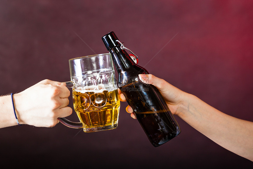 喝酒精派对放松庆祝概念喝啤酒吐司两个人碰了斯坦和啤酒瓶图片