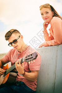 快乐的情侣和户外吉他音乐约会的概念快乐情侣和器男玩经典吉他的人图片