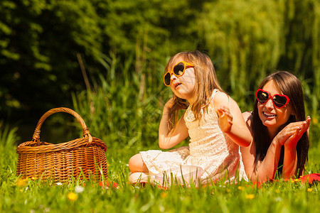 父母和女儿在野外餐时戴心形眼镜暑假休闲在公园草地享受家庭快乐放松图片