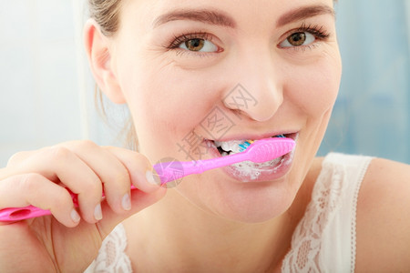 女人刷牙口腔卫生年轻女人刷牙浴室里有刷的女孩图片