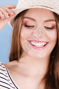 女人脸色多彩的眼睛化妆闭上蒙住头笑着看有趣的特写夏天时尚摄影棚拍蓝色图片