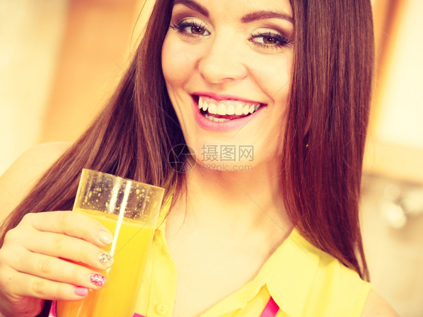家里厨房的女人喝着新鲜自制橙汁饮料健康食素减肥和人的概念图片