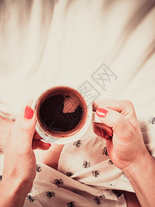 红指甲修的女握着咖啡杯图片