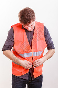身着安全背心的男工作和概念身着橙色制服安全背心的英俊年轻工人图片