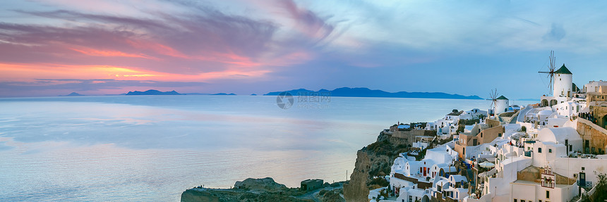 希腊圣托里尼岛的奥亚老城或伊岛白房子和日落时风车图片
