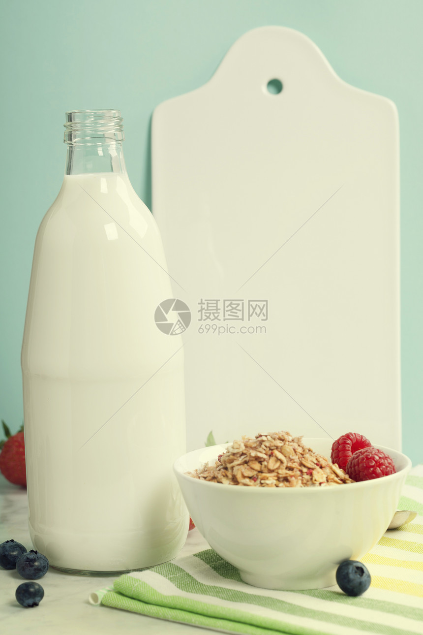 健康的早餐成分包括一瓶牛奶浆果木薯白陶瓷餐桌和大理石上的纸草蓝底白大理石桌健康饮食图片