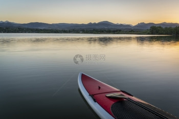 在黄昏的平静湖上和背景的落基山图片