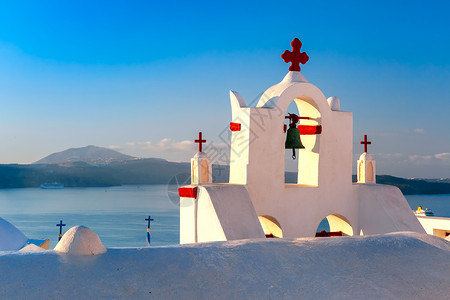 教堂钟声在希腊圣托里尼岛Oia或Ia的蓝海和天空背景下背景