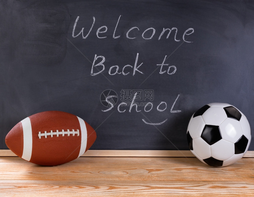 足球和台式在背景中抹黑纸板欢迎回到学校给生的信息图片